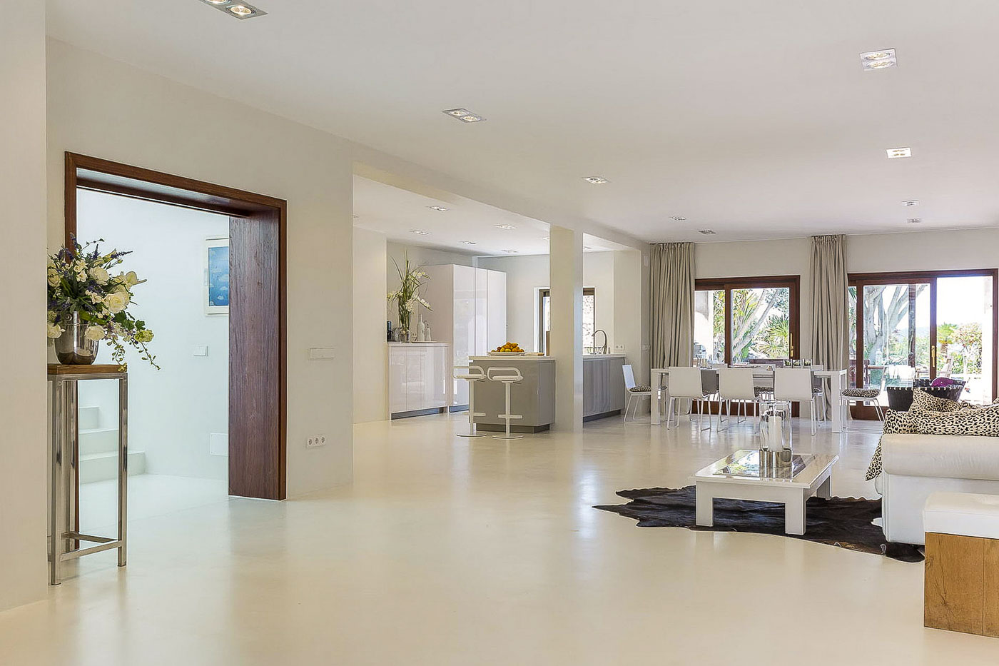 Amplia y elegante sala de estar de planta abierta en Ibiza Villa con cocina moderna y decoración elegante