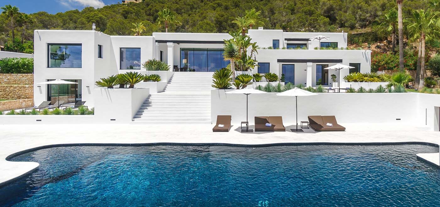 Luxurious Blakstad-designed villa in Ibiza showcasing sleek white architecture, an infinity pool, and lush landscaping