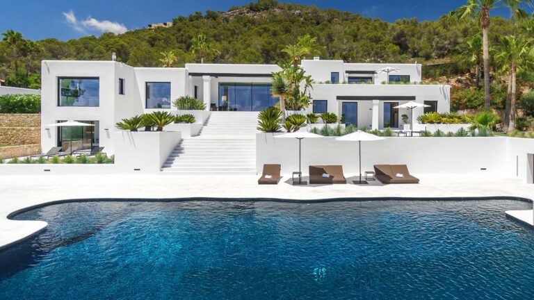 Lujosa villa diseñada por Blakstad en Ibiza que exhibe una elegante arquitectura blanca, una piscina infinita y un paisaje exuberante