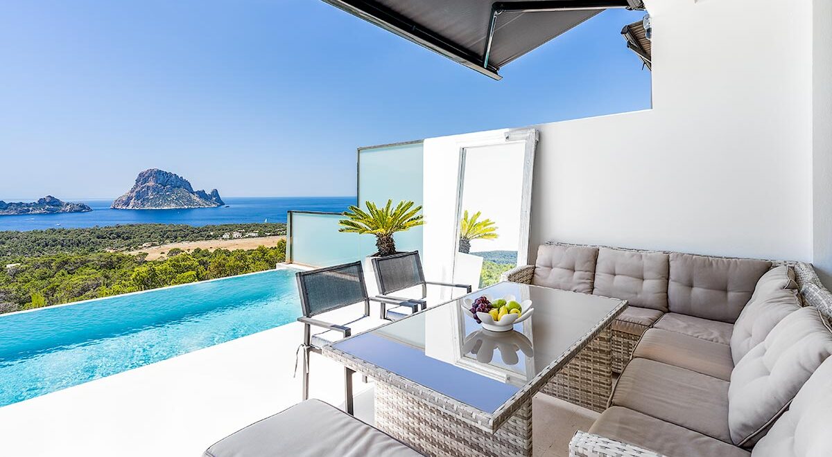 Balcón de lujosa villa en Ibiza con piscina infinita con vistas al mar Mediterráneo y a la isla de Es Vedrà