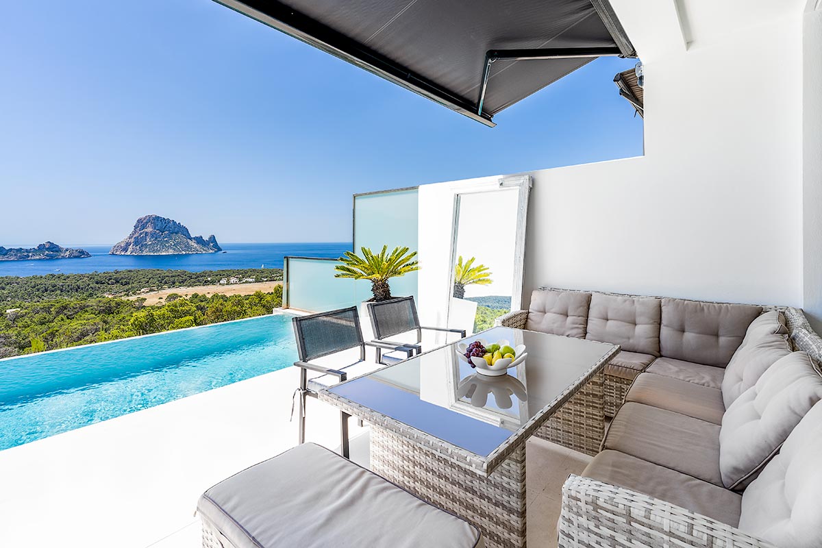 Luxurious Ibiza villa balcony with infinity pool overlooking the Mediterranean Sea and Es Vedrà island